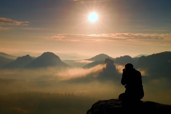 Zdjęcie ma zdjęcia jutrzenki powyżej ciężkich mgliste doliny. Pejzaż widok mglisty jesień wzgórza i sylwetka szczęśliwy człowiek — Zdjęcie stockowe
