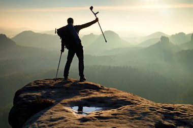 Fiyatı başının üstünde koltuk değneği ile. Derin vadi feryat adam siluet