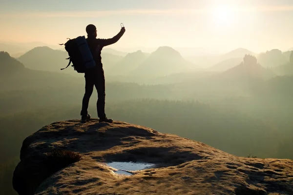 Homem tira fotos com smartphone nas montanhas nebulosas da manhã — Fotografia de Stock
