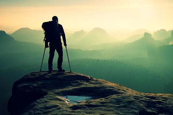 Turist med benet i stöldskyddet. Hiker siluett med medicin krycka på berg — Stockfoto