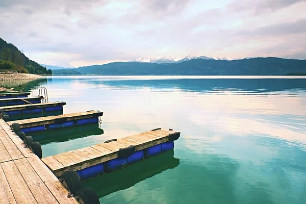 青いアルプス湖の空の木製のほくろ、雇われたボートのための埠頭 — ストック写真