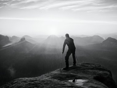 Kırık bacak ve tıp koltuk değneği ile kıvrık adam. Immobilizer bacağından ile uzun yürüyüşe çıkan kimse