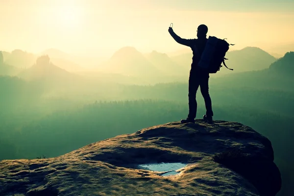 Strong hiker taking photo with smartphone, mountain peak — Stock Photo, Image