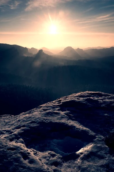 Sandsteingipfel aus schwerem orangefarbenen Nebel. starke Sonnenstrahlen — Stockfoto