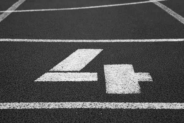 Número cuatro. Número de pista blanca en el circuito de caucho rojo, textura de las pistas de carreras en el estadio — Foto de Stock