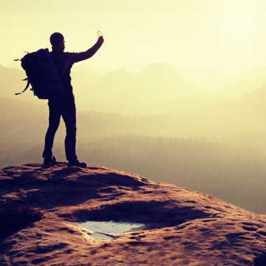 Adam sabah puslu dağlar smartphone ile fotoğraf çeker