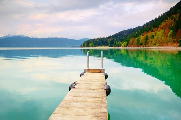 Lege houten mol op blauwe Alpen lake, wharf voor gehuurde boten in de jachthaven. Klaar voor de reis schepen. — Stockfoto