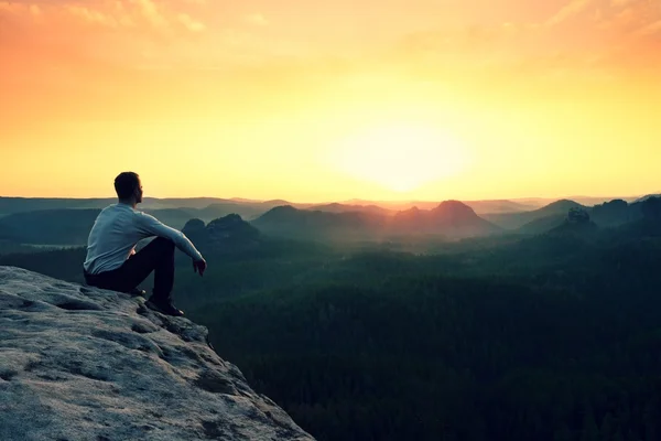 Tourist watching sunrise above  misty hilly valley — Stock Photo, Image