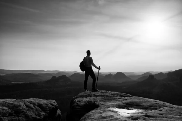 Skarpa silhuetten av aktiv man på bergstopp — Stockfoto