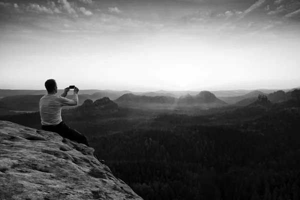 Tall tourist at dangerous cliff edge is taking selfie — Stock Photo, Image