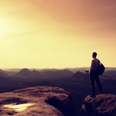 Turist cliff üzerinde el ile kutup kenar ve sırt çantası 