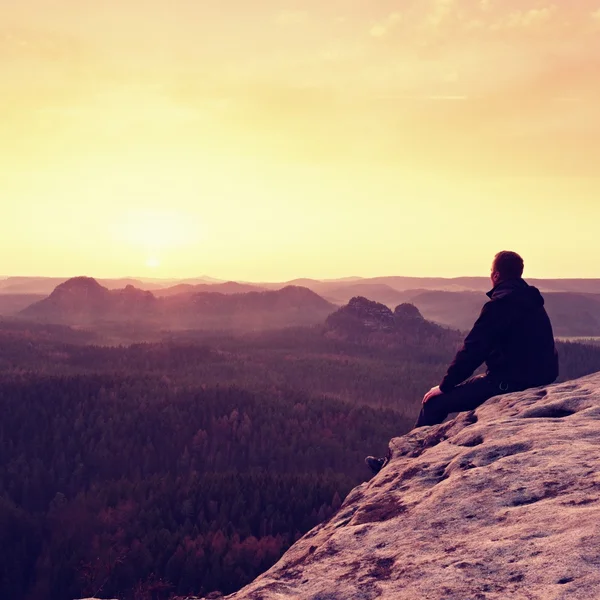 Uzun yürüyüşe çıkan kimse oturup Dağları'nda cliff ve enjoing bahar bakış — Stok fotoğraf