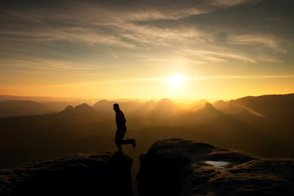 Jumping man. Young man makes step between cliffs. — Stock Photo, Image