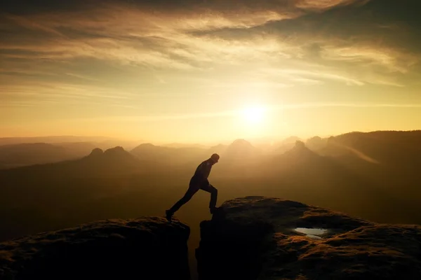 Skaczący Człowiek. Młody człowiek czyni krok między skały. — Zdjęcie stockowe