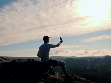 Gri t-shirt ve kırmızı beysbol şapkası turist fotoğraf çeker