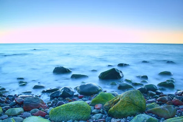 Mañana romántica en el mar. Grandes rocas que sobresalen del suave mar ondulado. Larga exposición — Foto de Stock