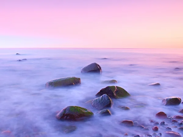 Ηλιοβασίλεμα στη βραχώδη ακτή της θάλασσας. Ταχύτητα κλείστρου χαμηλού για ομαλή στάθμη ύδατος και ονειρική αποτέλεσμα — Φωτογραφία Αρχείου