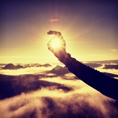 Man hand touch Sun. Misty daybreak in a beautiful hills.  clipart