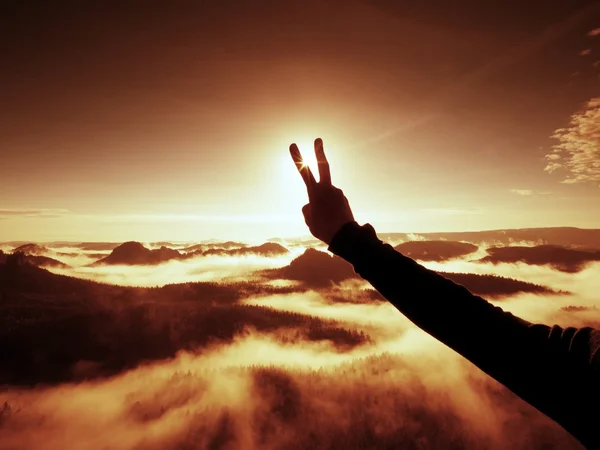 Man hand göra seger till Sun. Misty gryning i bergen — Stockfoto