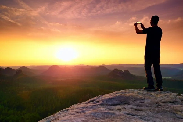 L'uomo scatta foto con il telefono su Rock Empire. Montagne nebbiose da sogno — Foto Stock