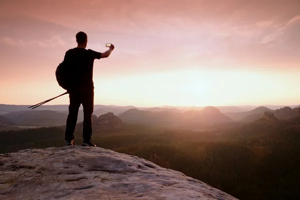 Tourist guide proped against pole in hand. Hiker with sporty backpack — Stock Photo, Image