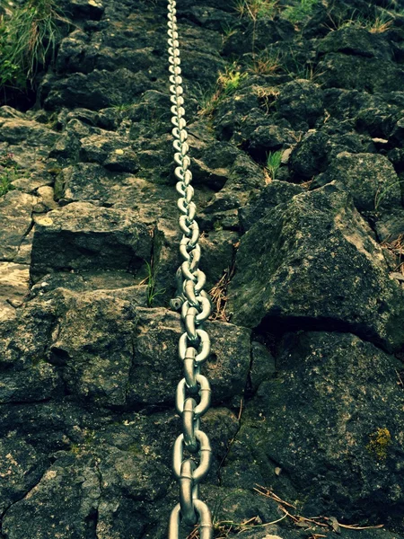 Detail of chain anchored in hard whinstone rock. Climbers path — Stock Photo, Image