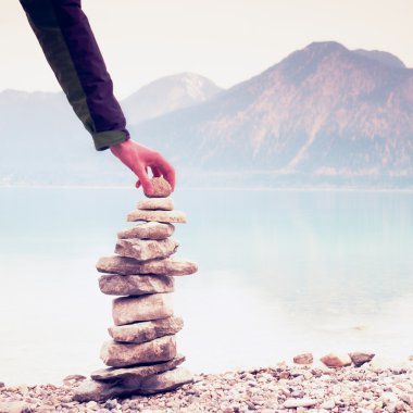 Adam çakıl üzerinden piramit inşa. Dengeli taşlar pyramide anılar