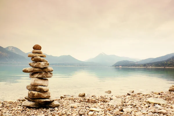 Zrównoważone pyramide kamień na brzegu, Niebieski Woda Jezioro góry. — Zdjęcie stockowe