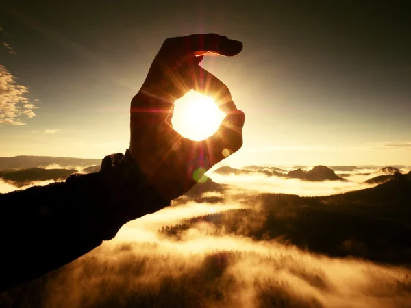 La mano del hombre toca Sun. Amanecer brumoso en una hermosa colina . — Foto de Stock