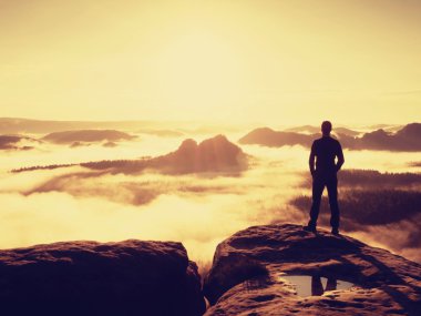 Siyah enjoing turuncu Sunrise bakış üzerinde uzun uzun yürüyüşe çıkan kimse. Ağır Sis feryat vadide.