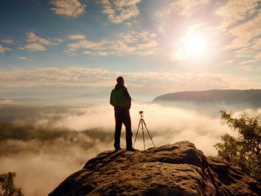 Profesyonel fotoğrafçı ile tripod ve kamera düşünme. Kremsi ağır sis ben