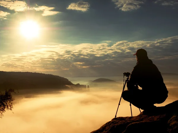 El fotógrafo trabaja con la cámara en el pico. Ambiente de ensueño en el paisajepaisaje , — Foto de Stock