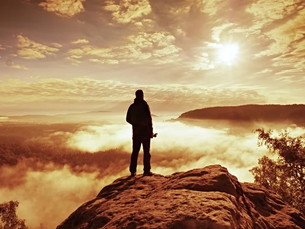 Fotografo con treppiede piegato alla fine del pensiero scogliera. Paesaggio nebbioso — Foto Stock