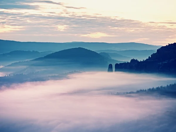 美しい妖精の谷で霧の憂鬱な夜明け。岩のピークがクリーミーな霧の雲をトリムします。 — ストック写真