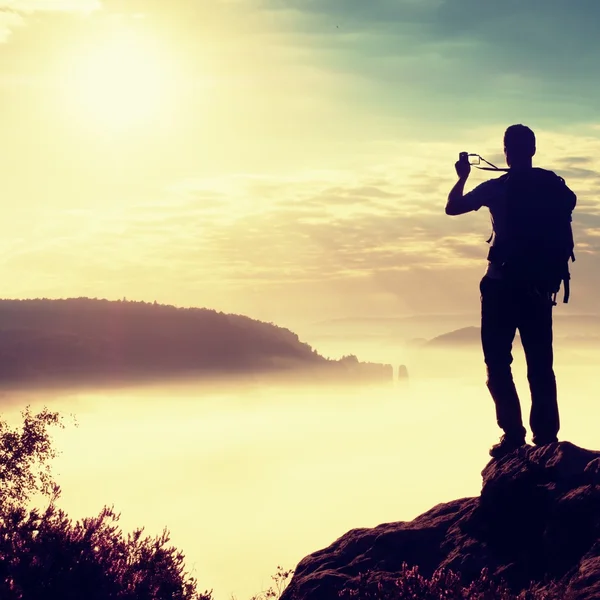 Homem forte caminhante tirar foto com telefone inteligente no pico da montanha . — Fotografia de Stock