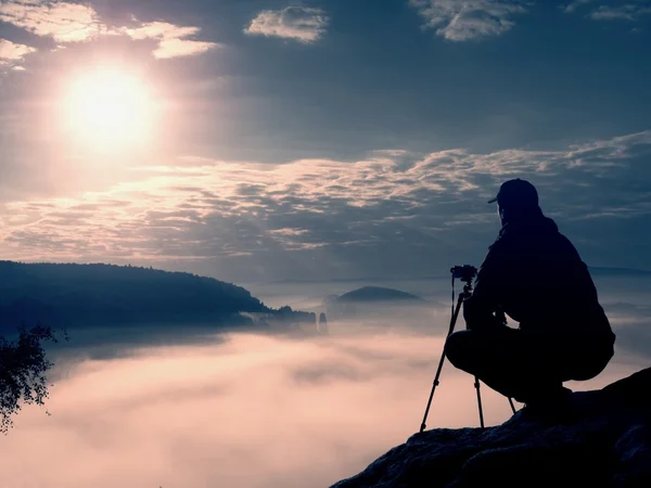 El fotógrafo trabaja con la cámara en el pico. Ambiente de ensueño en el paisajepaisaje , — Foto de Stock