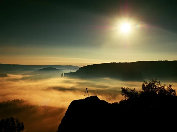 Trípode con cámara en pico listo para fotografía. Roca aumentada de niebla de oro . —  Fotos de Stock