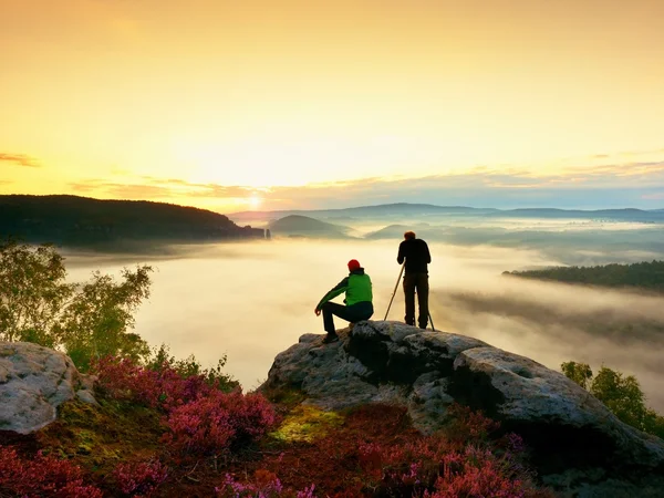 Uzun yürüyüşe çıkan kimse ve fotoğraf meraklısı ile tripod cliff üzerinde kalmak ve fotoğraf çeker. — Stok fotoğraf