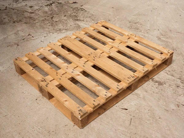 Wooden pallet on worn out concrete ground. Empty pallet