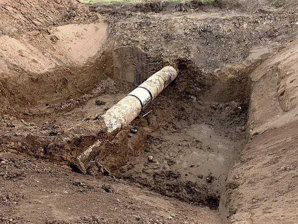 Fosa de excavación. Antiguo tubo de agua de bebida con miembros de la manga de reparación de acero inoxidable . — Foto de Stock