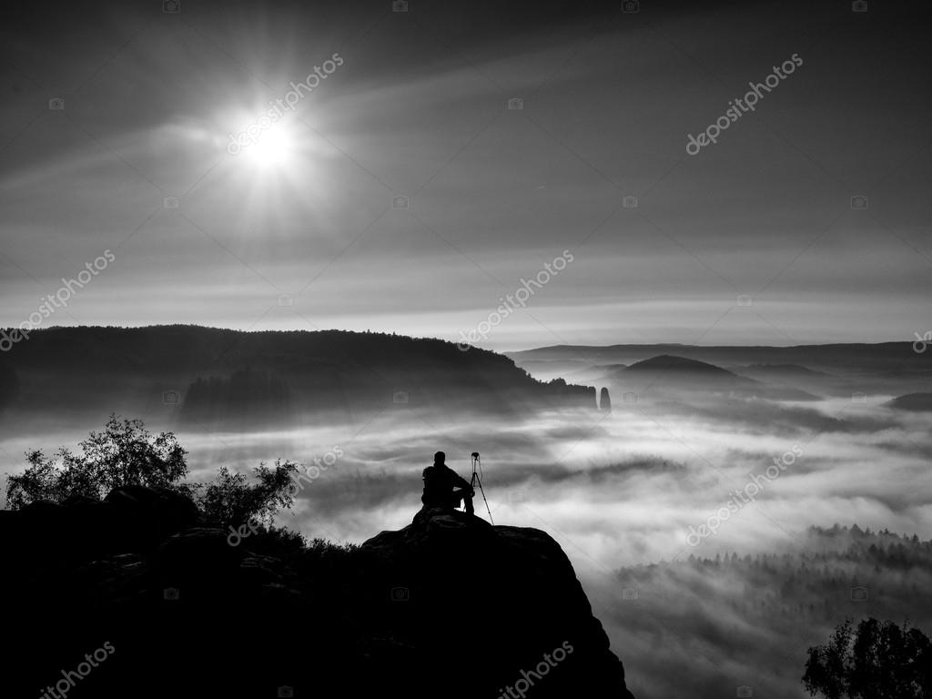 Tourist Sit On Peak Of Sandstone Rock And Watching Into Mist And Fog