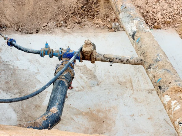 Fosa de excavación. Antiguo tubo de agua de bebida de 500 mm con brazo de 150 mm con válvulas de compuerta, accesorios de unión corroídos. Tubos antes de reparar las tuberías. Aislamiento del asfalto . — Foto de Stock