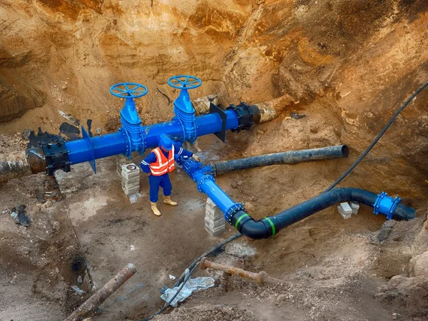 Travailleur souterrain à la vanne sur le système d'eau potable — Photo