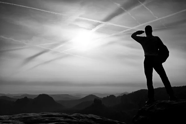 Man skuggar ögon. Ensam turist på cliff edge och titta in i djup dal bellow. Höst väder. — Stockfoto