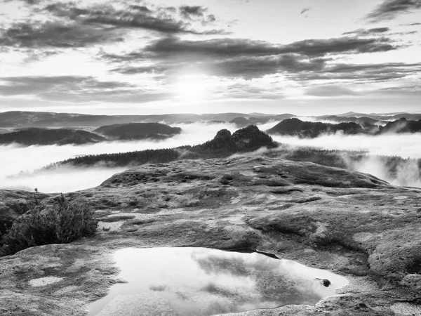 Black and white photo. Misty daybreak in a beautiful hills. Peaks of hills are sticking out from foggy background. — Stock Photo, Image