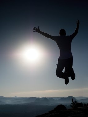  Genç deli adam kayada atlıyor. Adam atlama siluet 