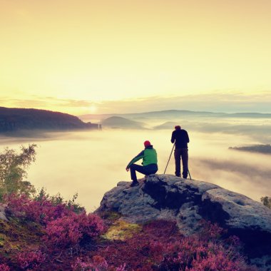 Uzun yürüyüşe çıkan kimse ve fotoğraf meraklısı ile tripod cliff üzerinde kalmak ve fotoğraf çeker.