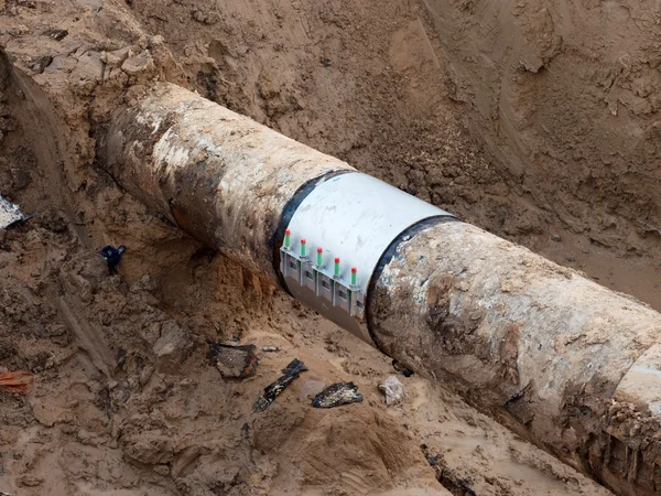 Fosse d'excavation. Ancien tuyau d'eau potable avec des éléments de manchon de réparation inoxydable . — Photo