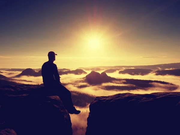 Moment van eenzaamheid. Man met GLB sit op berg en horloge te mist — Stockfoto