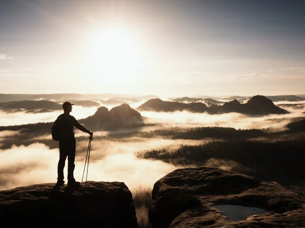 Silhouette of tourist with poles in hand. Sunny spring daybreak in rocky mountains. Hiker with sporty backpack — Stock Photo, Image
